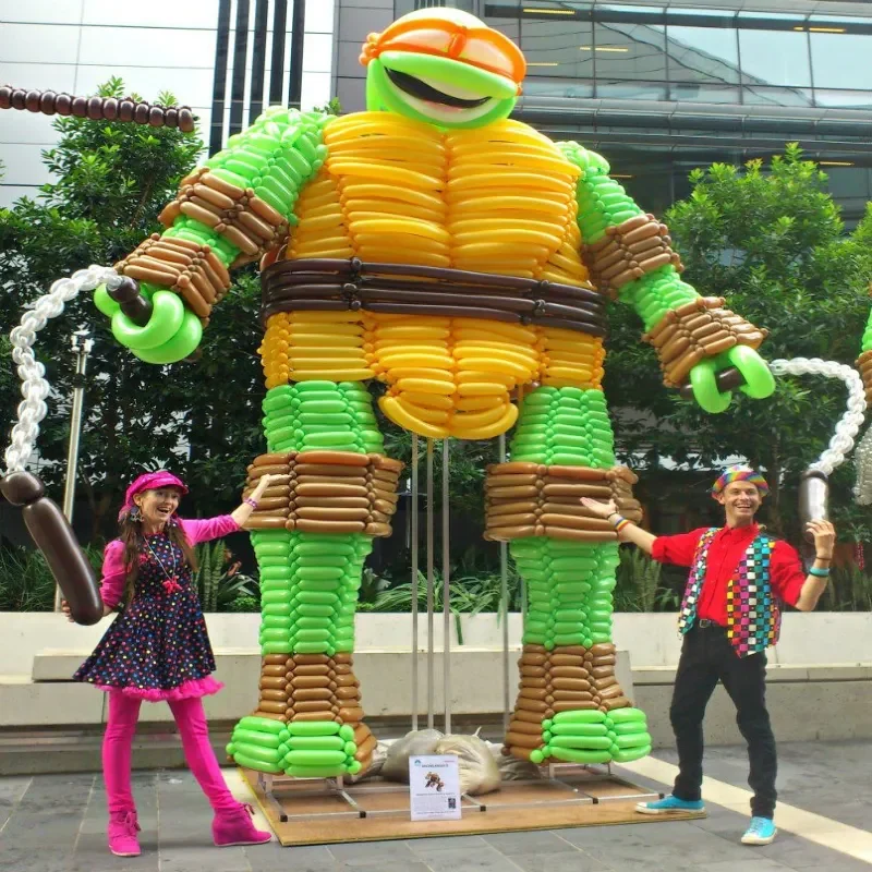 Kozi and Pinky Balloonists with a giant balloon sculpture of a Ninja turtle